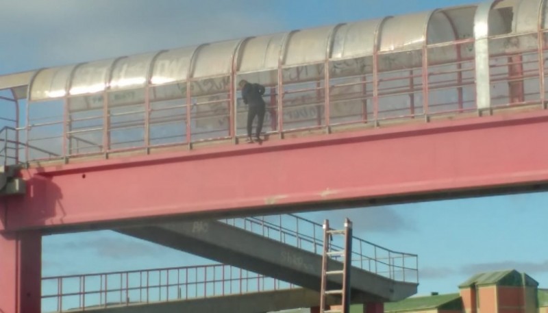 Mujer colgada de los puentes de la Autovía a punto de ser salvada por personal policial. 