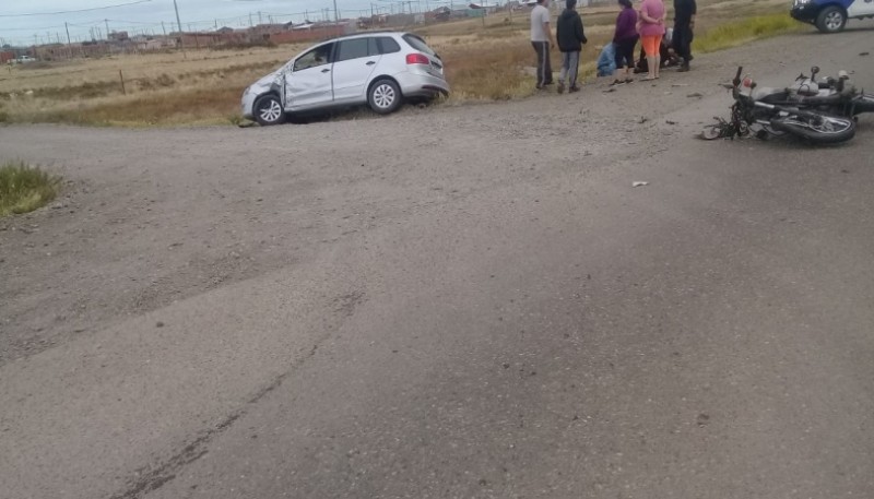 Colisión. Vecinos atienden al joven de la moto. 