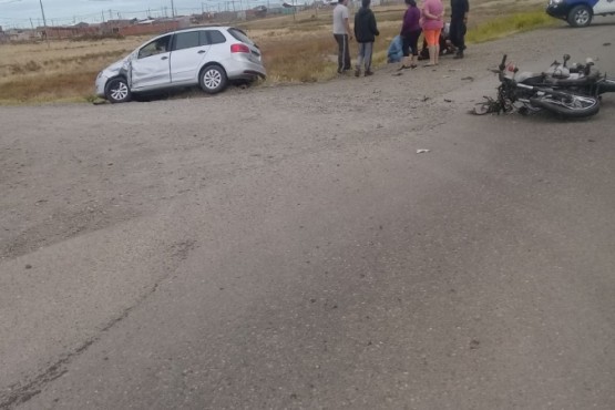 Colisión. Vecinos atienden al joven de la moto. 