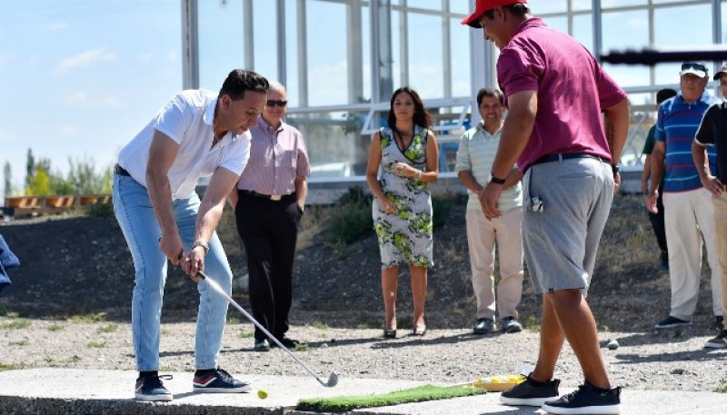 El intendente Maderna practica un golpe de golf. 