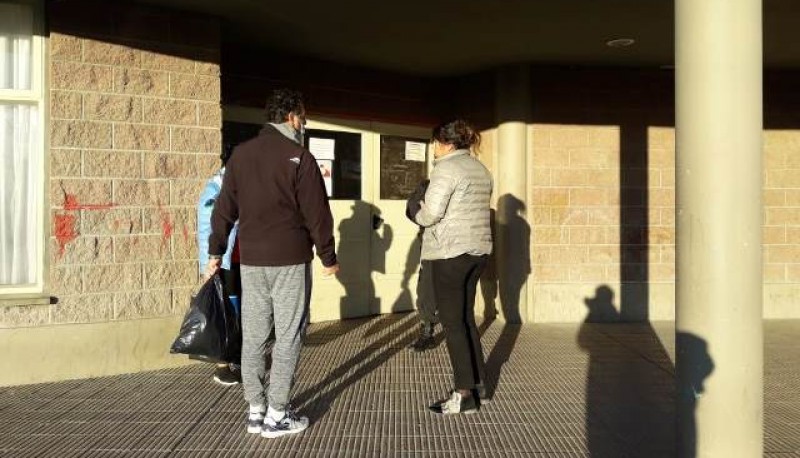 Juan Ramón con una bolsa de insumos en la puerta del Gimnasio 17 de Octubre. (Foto Ulises) 