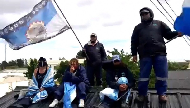 Los trabajadores trepados en el techo.