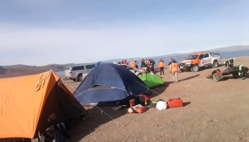 Los colaboradores en la búsqueda acampan en la orilla del lago.