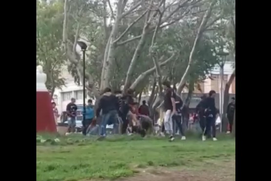 Jóvenes peleando en la plaza.