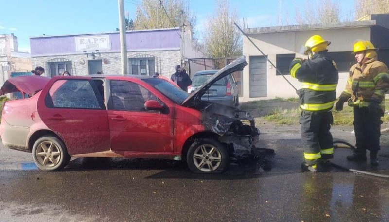 Bomberos trabajando sobre las llamas en el FIAT Siena (Foto: C.Robledo).