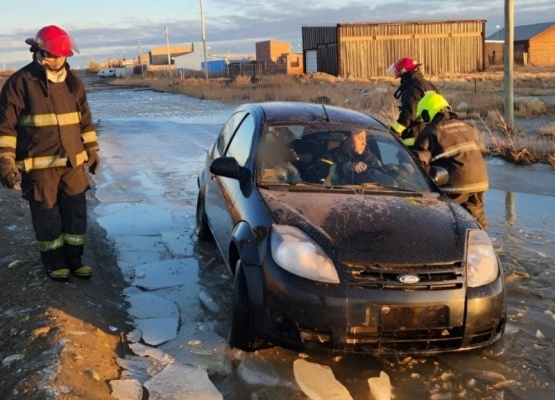 Rescatan a una mamá y a su hijo de un auto atascado en una laguna de hielo