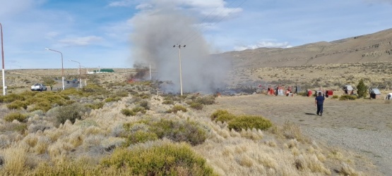 Bomberos y brigadistas intentan sofocar un incendio a la vera de la ruta
