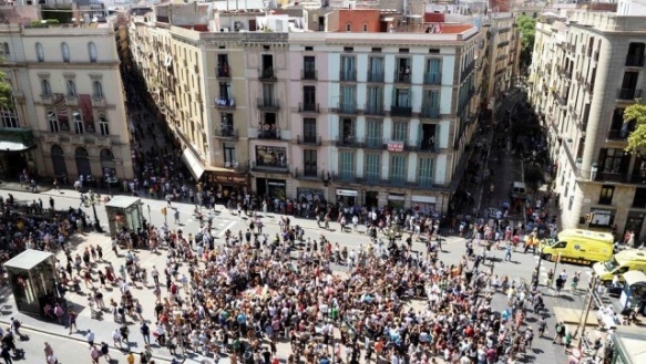 La gente camina por las Ramblas junto a un improvisado memorial en homenaje a las víctimas, en Barcelona. / AFP PHOTO / Josep Lago